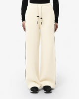 Pantaloni a gamba larga in scuba con piping in ecopelle