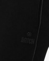 Pantaloni a gamba larga in scuba con piping in ecopelle